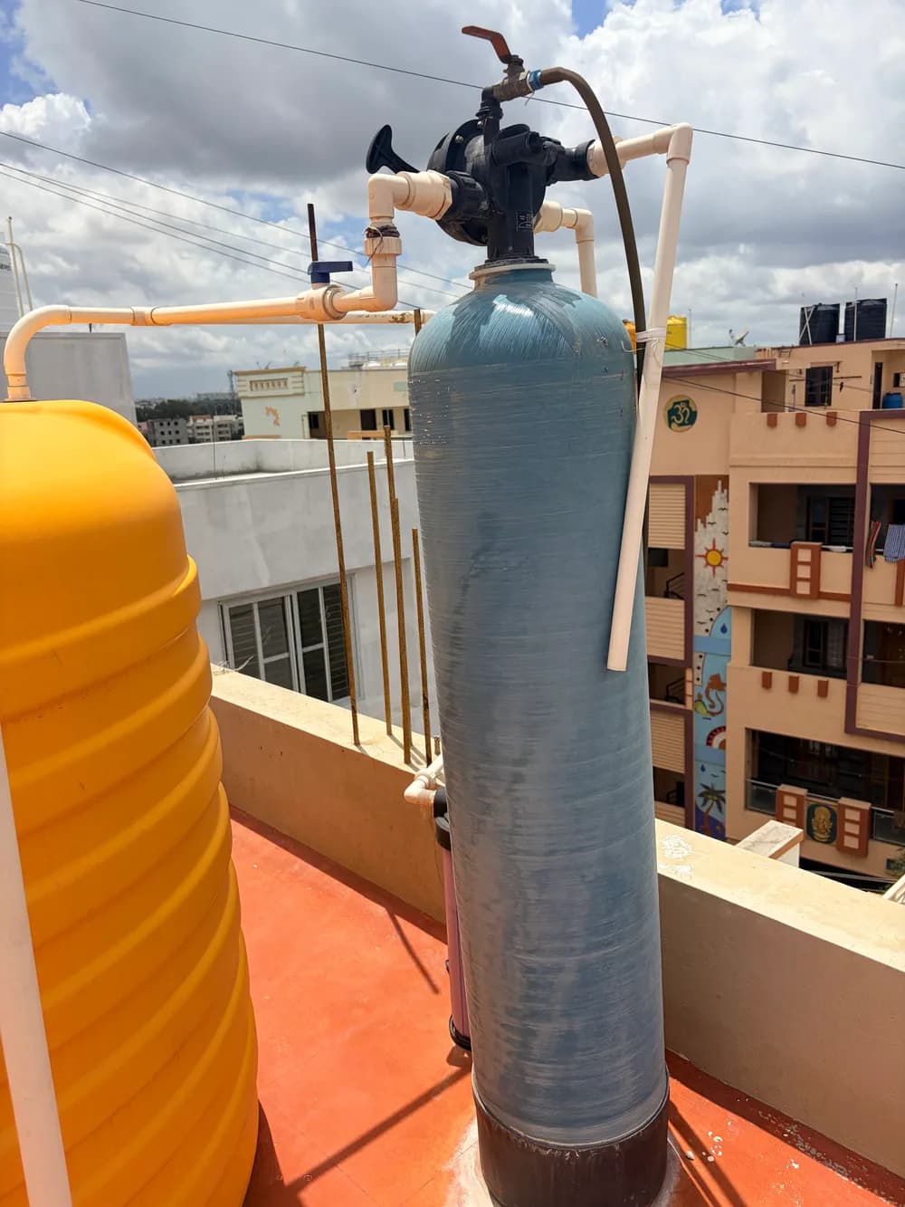 Outdoor water softener tank and connected plumbing, shown as an equipment example